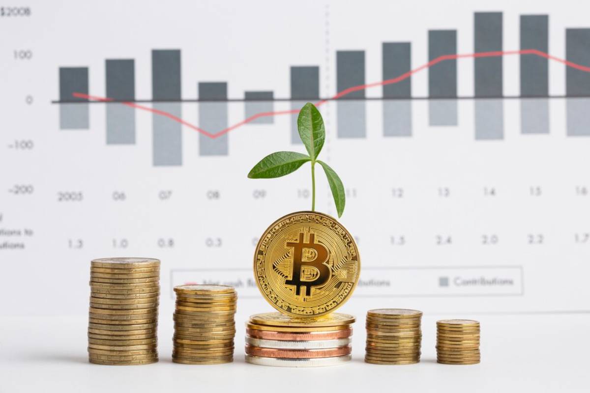 A Bitcoin coin topped with a small green plant, surrounded by stacks of coins, against a financial growth graph in the background.