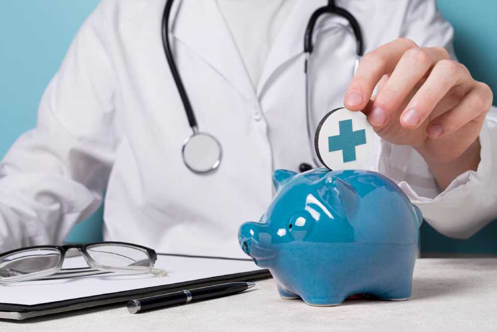 A doctor in a white coat deposits a healthcare symbol into a blue piggy bank, symbolizing Healthcare savings account.
