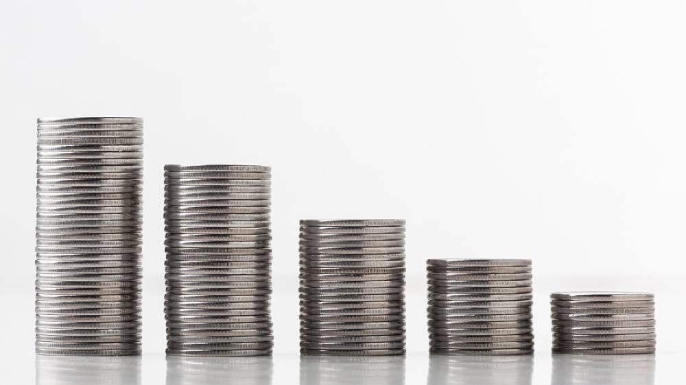 A series of stacked coins in varying heights, arranged in ascending order, set against a clean white background.