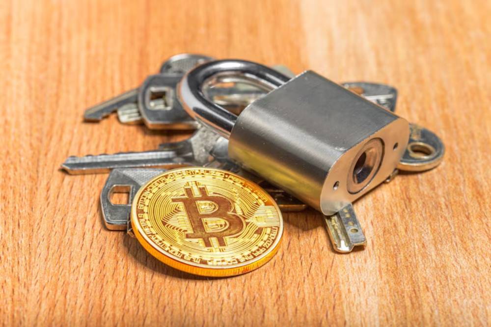 A golden Bitcoin sits among silver keys and a padlock on a wooden surface, symbolizing security in cryptocurrency.