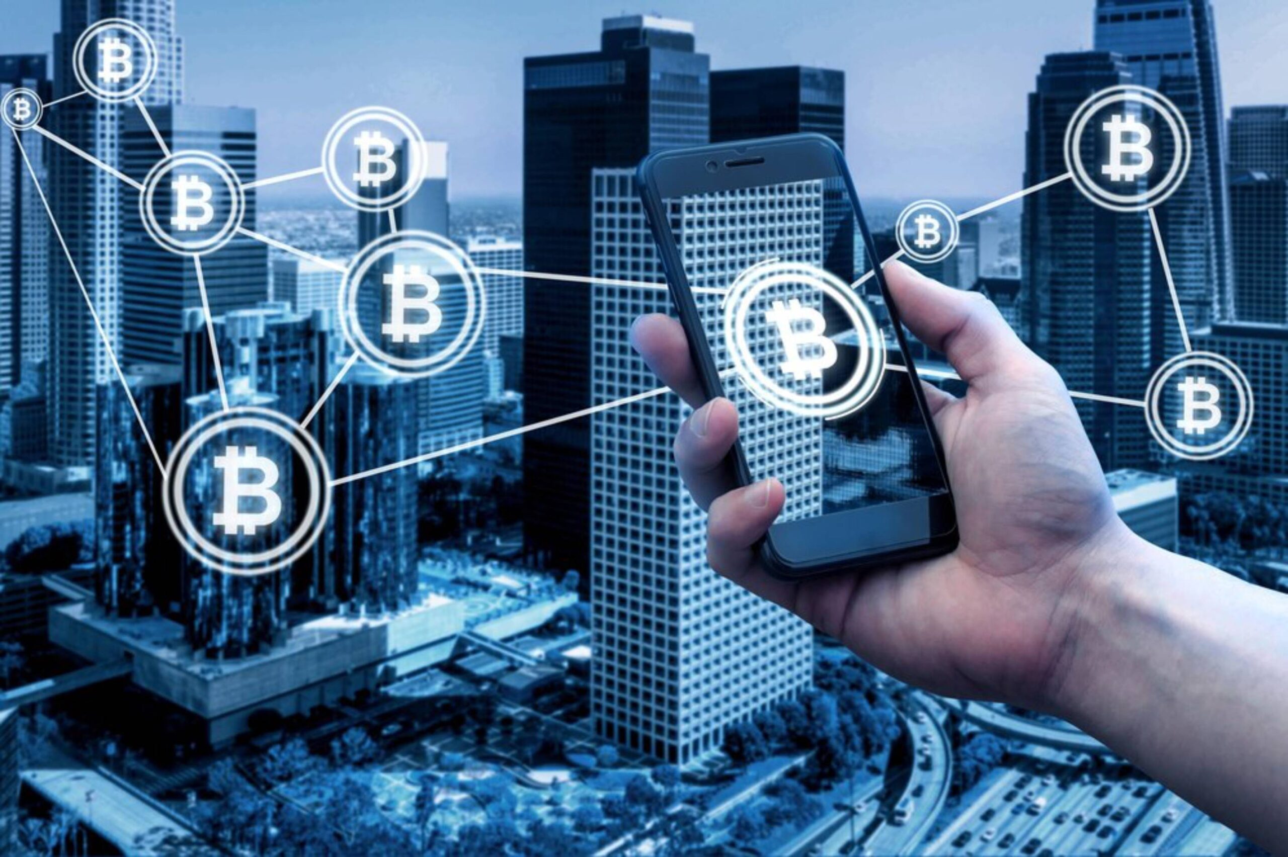 A hand holds a smartphone displaying a Bitcoin graphic, with skyscrapers and a digital network symbolizing cryptocurrency connections.